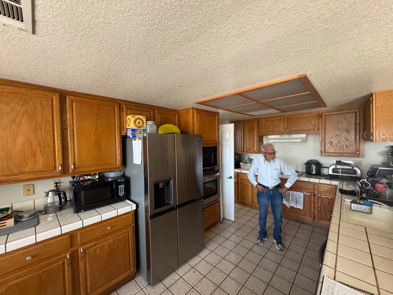 Kitchen before remodeling with oak cabinets and tile countertops